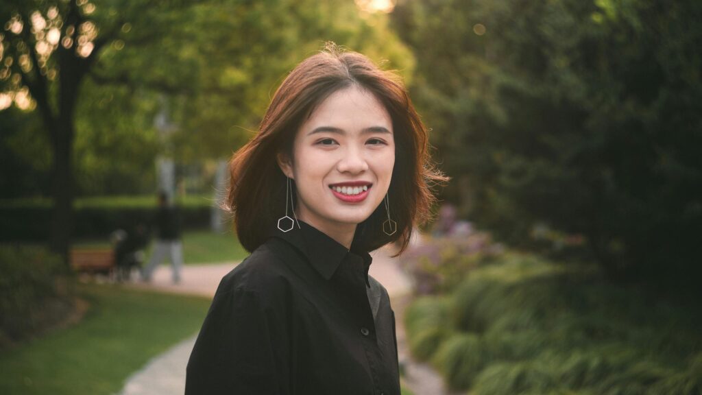Beautiful Asian Woman Smiling in Park Golden Hour Desktop Wallpaper