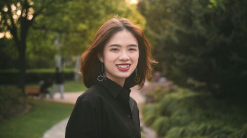 Beautiful Asian Woman Smiling in Park Golden Hour Desktop Wallpaper