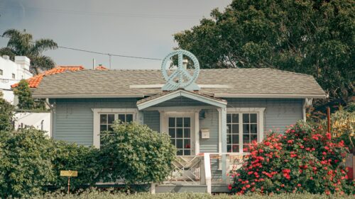 Charming Blue Cottage with Peace Sign Roof Decor 4K Desktop Wallpaper