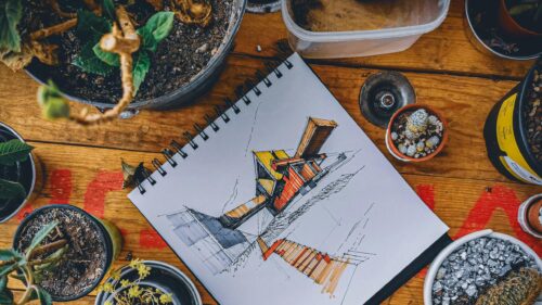 Architectural Sketch on Wooden Desk with Potted Plants PC Wallpaper