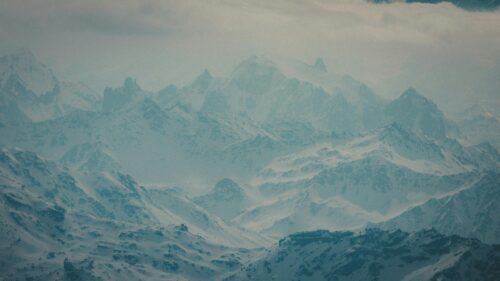 Majestic Snowy Peaks in Atmospheric Mist 4K Desktop Wallpaper