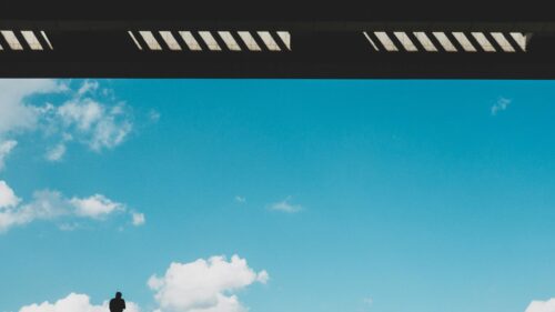 Minimalist Silhouette of a Man Against Blue Sky and Architecture 4K Wallpaper