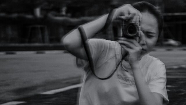 Young Photographer Capturing Moments Black and White Desktop Wallpaper