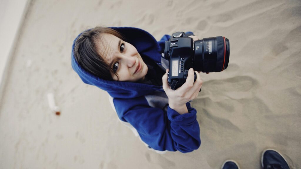 Photographer Girl with DSLR Camera on Sandy Beach Desktop Wallpaper