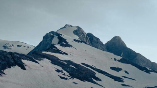 Majestic Snowy Mountain Peak Under Pale Sky 4K Desktop Wallpaper