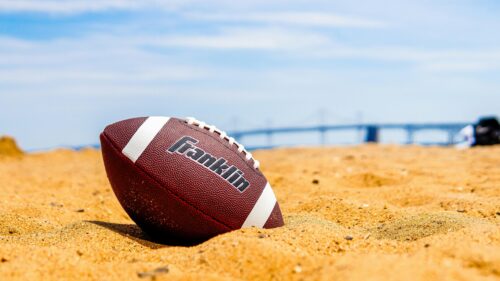 Franklin American Football Resting on Sunny Beach Sand 4K Wallpaper