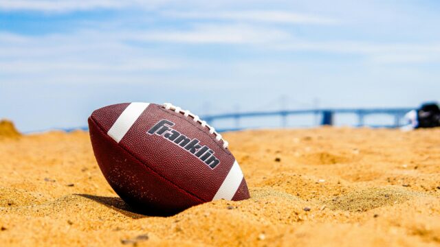 Franklin American Football Resting on Sunny Beach Sand 4K Wallpaper