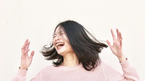 Joyful Young Woman Laughing with Hair Blowing in the Wind 4K Desktop Wallpaper