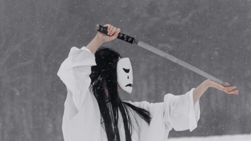 Mysterious Figure in White Mask with Katana in Snowy Forest 4K Wallpaper