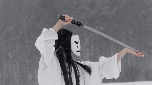 Mysterious Figure in White Mask with Katana in Snowy Forest 4K Wallpaper