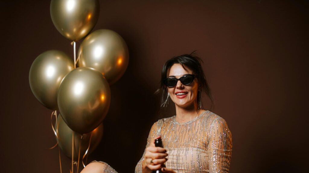 Elegant Glamorous Woman Celebrating with Champagne and Golden Balloons 4K Wallpaper