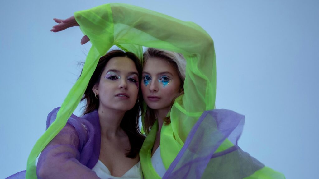 Two Fashionable Women with Glitter Makeup Neon Fashion 4K Wallpaper