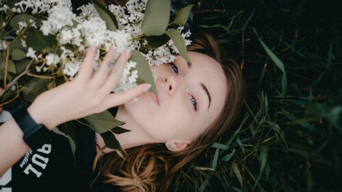 Girl Resting in Grass with White Lilacs 4K Wallpaper