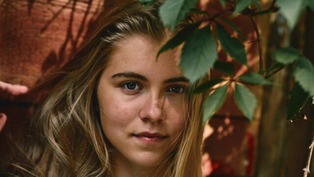 Portrait of a Natural Blonde Girl Near Foliage Desktop Wallpaper
