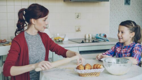 Mother and Daughter Baking Together in a Cozy Kitchen Desktop Wallpaper