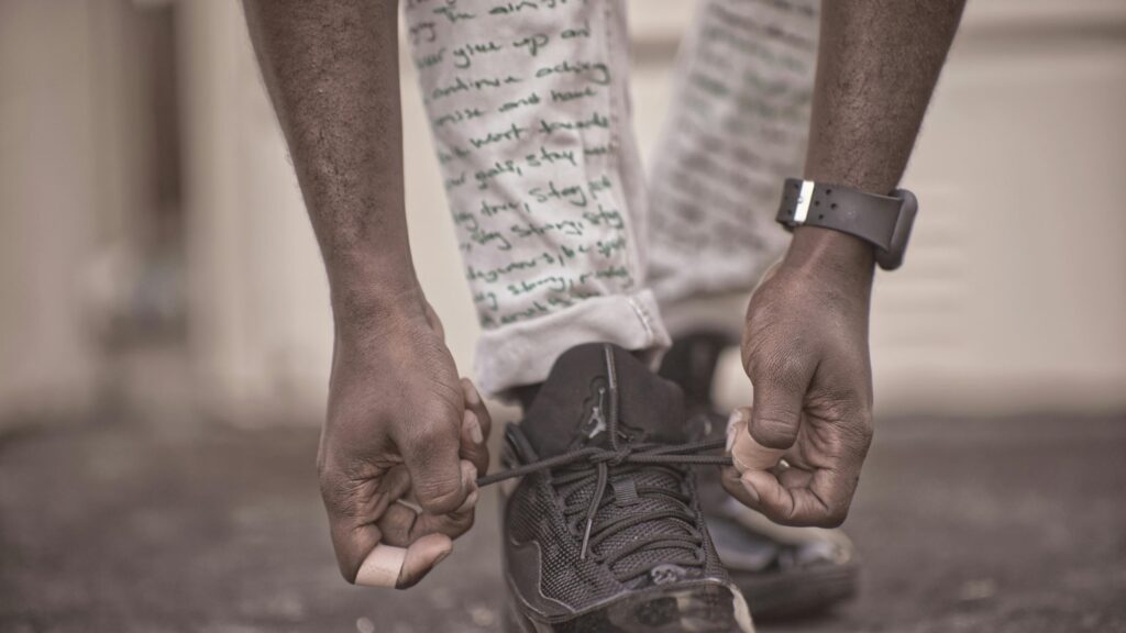 Close Up of Tying Shoelaces on Iconic Black Sneakers 4K Desktop Wallpaper