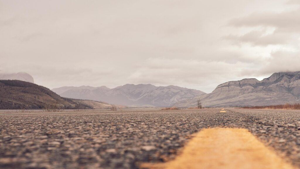 Low Angle Road View Toward Rugged Mountains 4K Wallpaper