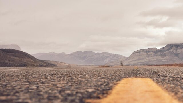 Low Angle Road View Toward Rugged Mountains 4K Wallpaper