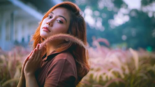 Asian Girl Holding Ornamental Grass in Meadow 4K Desktop Wallpaper