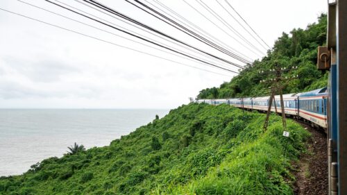 Scenic Coastal Train Journey Through Tropical Mountains 4K Wallpaper