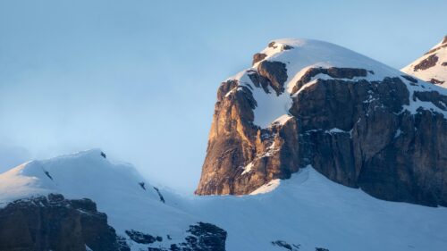 Golden Sunlight on Snowy Mountain Peak 4K Wallpaper