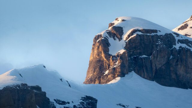 Golden Sunlight on Snowy Mountain Peak 4K Wallpaper