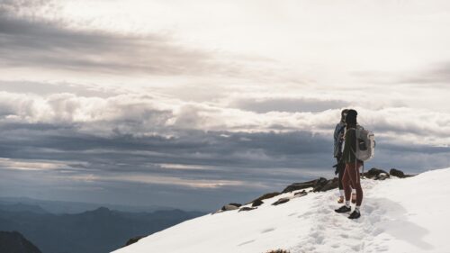 Hikers Overlooking Snowy Mountain Peaks 4K Desktop Wallpaper