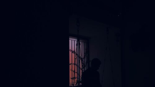 Silhouette of a Person Near a Window at Sunset Desktop Wallpaper
