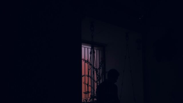 Silhouette of a Person Near a Window at Sunset Desktop Wallpaper