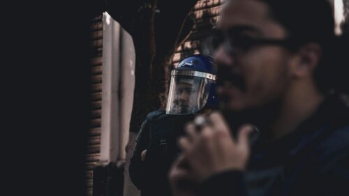 Riot Police Officer and Protester Close Up Desktop Wallpaper