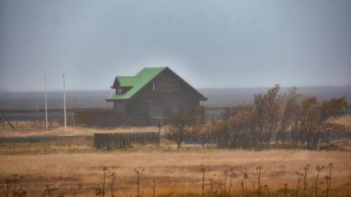 Lonely Wooden House with Green Roof in Misty Icelandic Landscape Desktop Wallpaper
