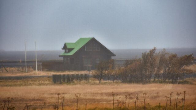 Lonely Wooden House with Green Roof in Misty Icelandic Landscape Desktop Wallpaper