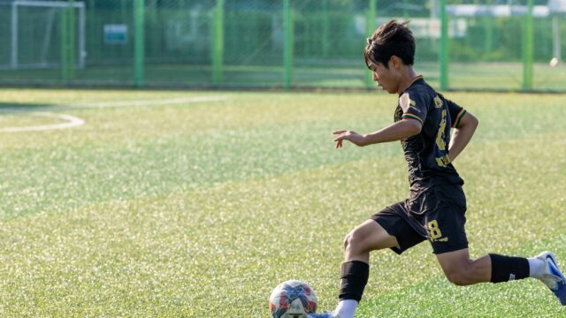 Young Soccer Player Dribbling on Grass Field Desktop Wallpaper