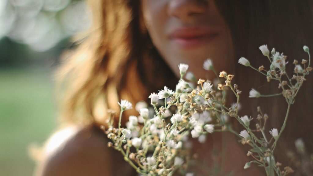 Woman Holding Wildflowers in Golden Hour Light Desktop Wallpaper