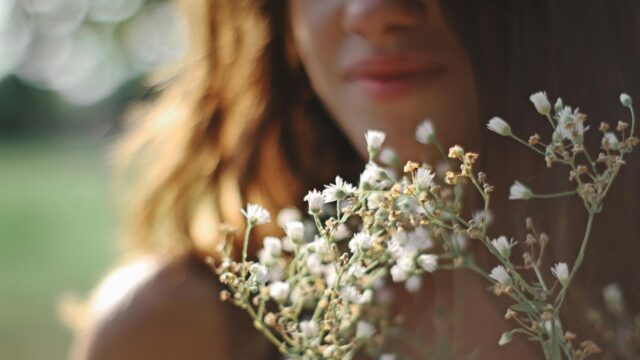 Woman Holding Wildflowers in Golden Hour Light Desktop Wallpaper