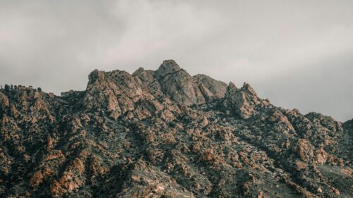 Rugged Mountain Peak Under Cloudy Sky 4K Desktop Wallpaper
