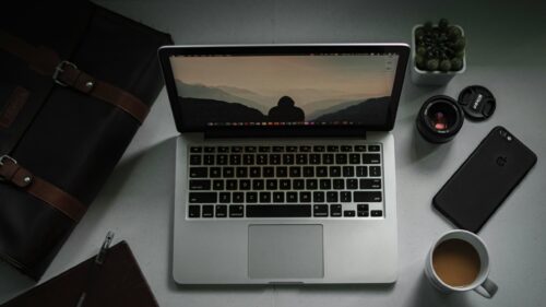 Minimalist Workspace with Laptop and Scenic Mountain View PC Wallpaper