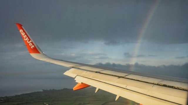 EasyJet Airplane Wing with Rainbow Over Scenic Landscape 4K Wallpaper