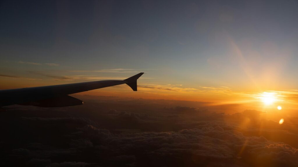 Golden Sunset View from Airplane Window Above Clouds 4K Wallpaper