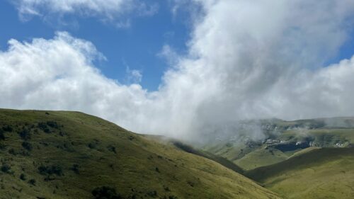 Breathtaking Green Mountain Peaks Under Rolling Clouds PC Wallpaper