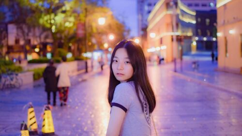 Asian Girl Walking Down a Street at Twilight 4K Desktop Wallpaper