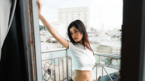 Beautiful Asian Woman Leaning on Balcony at Sunset 4K Desktop Wallpaper