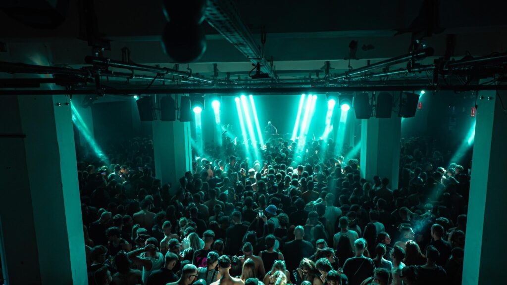 Atmospheric Nightclub Crowd Under Teal Stage Lights 4K Wallpaper