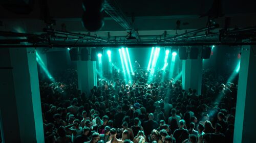 Atmospheric Nightclub Crowd Under Teal Stage Lights 4K Wallpaper
