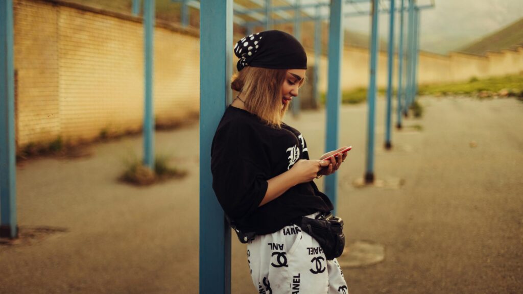 Stylish Woman Checking Phone by Urban Pillar Desktop Wallpaper