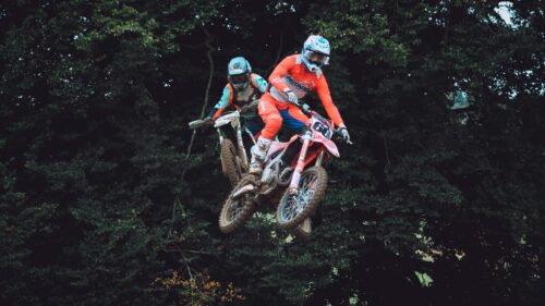 Two Motocross Riders Jumping Mid-Air Action PC Wallpaper