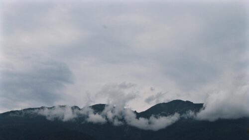 Misty Mountains Under Dramatic Cloudy Sky PC Wallpaper