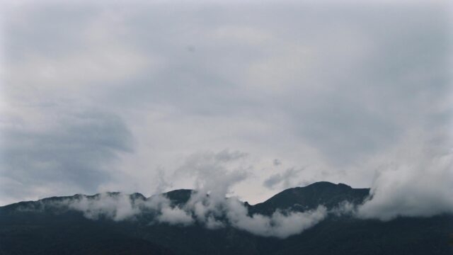 Misty Mountains Under Dramatic Cloudy Sky PC Wallpaper