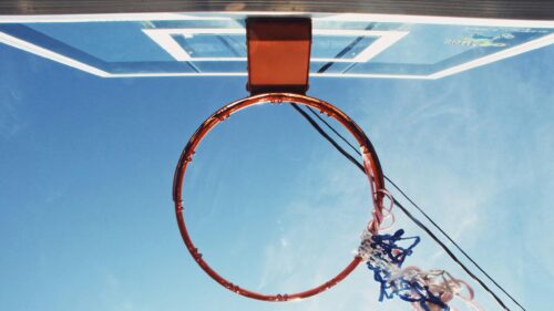 Low Angle Basketball Rim Against Clear Blue Sky 4K Wallpaper