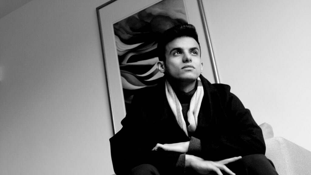 Elegant Young Man in Black Coat Looking Up Minimalist Desktop Wallpaper